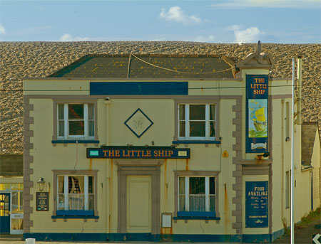 Chesil Bank looms over a pub in Chiswell