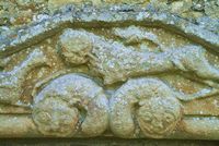 Carving above the exterior of the north door of the church (filled in) . The carving represents a griffin and a lion trampling two serpents. The latter is thought to represent the triumph of good over evil.