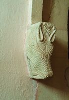 Head of a mythical beast carved into the drip-stop of the west door.